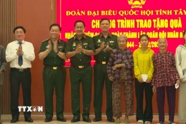 Đại tướng Nguyễn Trọng Nghĩa và Bí thư Tỉnh ủy Tây Ninh Nguyễn Văn Quyết trao quà cho gia đình chính sách, hộ nghèo xã Đức Huệ. (Ảnh: Thanh Bình/TTXVN)