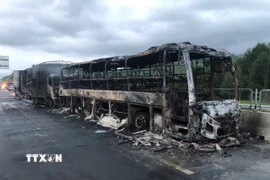 Cả ba phương tiện đều bị lửa thiêu rụi; trong đó xe tải và xe khách cháy hoàn toàn, xe đầu kéo bị cháy phần đầu. (Ảnh: TTXVN phát)