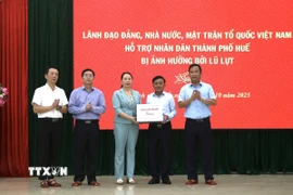 Thường trực Ban Bí thư Trần Cẩm Tú (thứ 2, phải sang) trao quà của lãnh đạo Đảng, Nhà nước cho thành phố Huế. (Ảnh: Mai Trang/TTXVN)