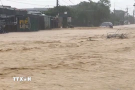 Mưa lớn khiến cho tuyến đường tại phường Vũng Áng ngập, nước chảy xiết. (Ảnh: TTXVN phát)