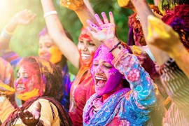 Những người phụ nữ Ấn Độ tung bột màu trong lễ hội Holi.