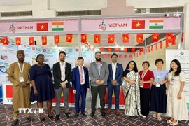 Tham tán Thương mại Bùi Trung Thướng (thứ 4 từ trái sang) chụp ảnh lưu niệm của các quan khách trong và ngoài nước tới tham quan gian hàng. (Ảnh: Ngọc Thúy/TTXVN)