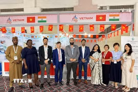 Tham tán Thương mại Bùi Trung Thướng (thứ 4 từ trái sang) chụp ảnh lưu niệm của các quan khách trong và ngoài nước tới tham quan gian hàng. (Ảnh: Ngọc Thúy/TTXVN)