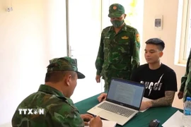 Cán bộ Đồn Biên phòng Cửa khẩu Mỹ Quý Tây, Ban Chỉ huy Bộ đội Biên phòng tỉnh Tây Ninh lấy lời khai của một trong bốn đối tượng. (Ảnh: TTXVN phát)