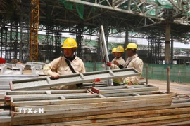 Công nhân di chuyển giàn giáo sau khi hoàn thành các công việc tại phần mái nhà ga hành khách sân bay Long Thành. (Ảnh: Công Phong/TTXVN)