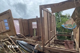 Một phần ngôi nhà bị lât ngược do nước lũ cuốn. (Ảnh: Văn Tý/TTXVN)