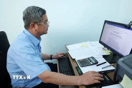 Ông Nguyễn Ngọc Giao, Trưởng phòng Nông nghiệp và Phát triển Nông thôn huyện Cư M’Gar, tỉnh Đắk Lắk viết đơn xin nghỉ hưu trước tuổi. (Ảnh: Hoài Thu/TTXVN)