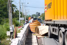Hiện trường vụ tai nạn trên Quốc lộ 22B giữa xe container và xe máy. (Ảnh: Minh Phú/TTXVN)