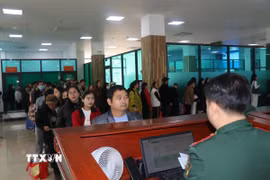 Du khách xếp hàng chờ làm thủ tục xuất nhập cảnh qua cửa khẩu Quốc tế Lào Cai. (Ảnh Hồng Ninh/TTXVN)