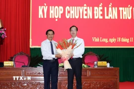 Bí thư Tỉnh ủy Vĩnh Long Trần Văn Lâu tặng hoa chúc mừng ông Trần Trí Quang được bầu giữ chức Chủ tịch Ủy ban Nhân dân tỉnh Vĩnh Long. (Ảnh: Phạm Minh Tuấn/TTXVN)