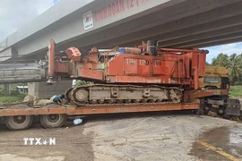 Hiện trường chiếc xe ben vận chuyển thiết bị làm đường cao tốc bị lún bánh. (Ảnh: Tuấn Phi/TTXVN)