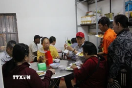 Những người dân đến ăn cơm chay tại chùa Tổ đình Nghĩa Phương. (Ảnh: Phan Sáu/TTXVN)