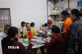 Những người dân đến ăn cơm chay tại chùa Tổ đình Nghĩa Phương. (Ảnh: Phan Sáu/TTXVN)