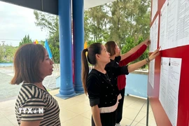 Cử tri xem bảng niêm yết danh sách chính thức, tiểu sử tóm tắt những người ứng cử đại biểu Quốc hội khóa XVI và đại biểu Hội đồng Nhân dân tỉnh Quảng Trị nhiệm kỳ 2026-2031. (Ảnh: TTXVN phát)