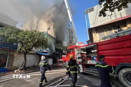 Lực lượng chức năng đang nỗ lực dập tắt đám cháy. (Ảnh: Thành Phương/TTXVN)