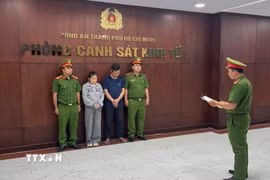 Cơ quan điều tra tống đạt quyết định bắt giữ các đối tượng. (Ảnh: TTXVN phát)