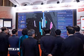 Chủ tịch Quốc hội Trần Thanh Mẫn và đại biểu nghe thuyết trình về đổi mới hoạt động của Hội đồng Nhân dân thành phố Hà Nội. (Ảnh: Doãn Tấn/TTXVN)
