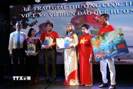 Đại sứ Vũ Quang Minh (ngoài cùng bên trái) trao Giải Nhất cho ba thí sinh dự thi ở các thể loại văn xuôi, thơ và tranh vẽ. (Ảnh: Thu Hằng/TTXVN)