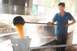 Một mẻ mật mía trải qua khoảng thời gian nấu từ 3 đến 4 giờ. Trong đó, hơn nửa thời gian mật mía mới sủi tăm và sôi. Khi mật mía sôi, người nấu phải luôn tay vớt bọt và tạp chất nổi lên trong các chảo nấu để đảm bảo mật mía có chất lượng, màu sắc đẹp. (Ảnh: Xuân Tiến/TTXVN)