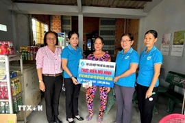 Chị Đặng Thị Huê, vượt khó nuôi con học đại học, nhận vốn cho vay của Hội Liên hiệp Phụ nữ xã Long Cang, tỉnh Tây Ninh. (Ảnh: Đức Hạnh/TTXVN)