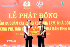 Trung tướng Phạm Thế Tùng, Ủy viên Ban Thường vụ Đảng ủy Công an Trung ương, Thứ trưởng Bộ Công an trao biểu trưng hỗ trợ kinh phí xóa 500 căn nhà tạm, nhà dột nát cho tỉnh Đắk Nông. (Ảnh: TTXVN phát)