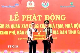 Trung tướng Phạm Thế Tùng, Ủy viên Ban Thường vụ Đảng ủy Công an Trung ương, Thứ trưởng Bộ Công an trao biểu trưng hỗ trợ kinh phí xóa 500 căn nhà tạm, nhà dột nát cho tỉnh Đắk Nông. (Ảnh: TTXVN phát)