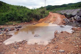 Người dân phải mở các lối đi tạm vòng qua những điểm sạt lở. (Ảnh: Tá Chuyên/TTXVN)