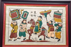 Tranh Đông Hồ "Vinh quy bái tổ". (Ảnh: Thanh Thương/TTXVN)