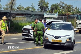 Cơ quan chức năng khám nghiệm hiện trường vụ việc đối tượng đập phá chiếc xe taxi do mâu thuẫn gia đình tại phường B'Lao. (Ảnh TTXVN phát)
