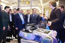 Thủ tướng Phạm Minh Chính xem sản phẩm nghiên cứu của sinh viên Đại học Nghiên cứu Công nghệ Quốc gia MISIS. (Ảnh: Dương Giang/TTXVN)