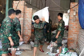 Cán bộ, chiến sỹ Sư đoàn 304 hỗ trợ người dân xã Bình Nguyên di chuyển tài sản đến nơi an toàn. (Ảnh: TTXVN phát)