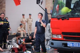 Lực lượng chức năng cố gắng dập tắt đám cháy. (Ảnh: Hoàng Hiếu/TTXVN)