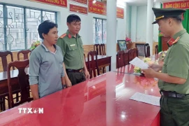 Cơ quan An ninh điều tra Công an tỉnh An Giang tống đạt lệnh khởi tố vụ án, khởi tố bị can, thực hiện lệnh bắt bị can tạm giam đối tượng Giang Chí Hùng. (Ảnh: TTXVN phát)