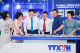Đồng chí Nguyễn Trọng Nghĩa, Ủy viên Bộ Chính trị, Bí thư Trung ương Đảng, Trưởng Ban Tuyên giáo và Dân vận Trung ương cùng các đại biểu tham quan gian trưng bày của TTXVN tại Hội báo. (Ảnh: Minh Quyết/ TTXVN)
