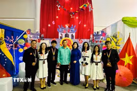 Đại sứ Vũ Trung Mỹ chụp ảnh cùng nhóm sinh viên Venezuela xây dựng Không gian “Việt Nam - Đất nước, Con người”. (Ảnh: TTXVN phát)