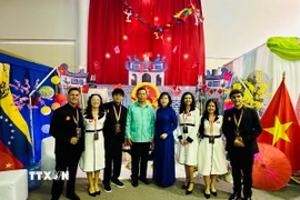 Đại sứ Vũ Trung Mỹ chụp ảnh cùng nhóm sinh viên Venezuela xây dựng Không gian “Việt Nam - Đất nước, Con người”. (Ảnh: TTXVN phát)