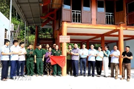 Chủ tịch Ủy ban Nhân dân tỉnh Hà Giang Phan Huy Ngọc và các đại biểu động viên, tặng quà và chúc mừng gia đình ông Nguyễn Viết Đôn ở xã Đồng Yên, huyện Bắc Quang, khánh thành ngôi nhà mới. (Ảnh: Kim Tiến/TTXVN phát)