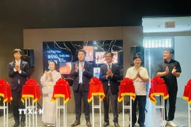 Các đại biểu thực hiện nghi thức cắt băng khai mạc triển lãm “Dáng hình của đất”. (Ảnh: Tuyết Mai/TTXVN)