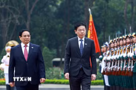 Thủ tướng Phạm Minh Chính và Thủ tướng Singapore Lawrence Wong duyệt Đội danh dự Quân đội nhân dân Việt Nam. (Ảnh: Dương Giang/TTXVN)