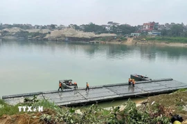 Các lực lượng quân đội đang khẩn trương thi công lắp đặt cầu phao qua sông Lô phục vụ nhân dân đón Tết Nguyên đán 2026. (Ảnh: Nguyễn Văn Cảnh/TTXVN)