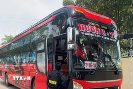 Cảnh sát dừng xe kiểm tra xe khách nhồi nhét khách. (Ảnh: TTXVN phát)