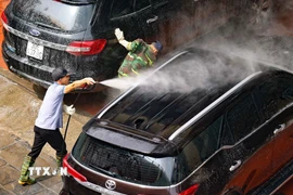 Người làm dịch vụ rửa xe luôn tay không nghỉ trong những ngày cận Tết. (Ảnh: Thanh Tùng/TTXVN)