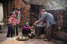 Các thế hệ trong gia đình quây quần bên bên nồi bánh chưng. (Ảnh: Khánh Hòa/TTXVN)