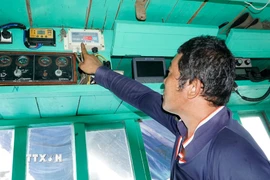 Ngư dân Gia Lai kiểm tra thiết bị giám sát hành trình trước khi đi biển. (Ảnh: Đình Quân/TTXVN)