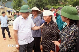 Phó Thủ tướng Chính phủ Lê Thành Long thăm hỏi, động viên gia đình bị thiệt hại về người do mưa lũ ở xã Chiềng Sơ. (Ảnh: Quang Quyết/ TTXVN)