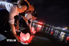 Các đại biểu thả đèn hoa đăng trên sông Đà. (Ảnh: Trọng Đạt/TTXVN)