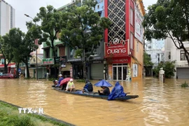 Người dân vẫn di chuyển bằng thuyền trên các tuyến đường chính ở trung tâm thành phố Huế. (Ảnh: Văn Dũng/TTXVN)