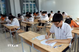 Các thí sinh ghi thông tin trên bài thi. (Ảnh: Nguyễn Lành/ TTXVN)