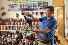 Du khách tìm hiểu sản phẩm gốm tại Hợp tác xã gốm Chăm Bàu Trúc (huyện Ninh Phước, Ninh Thuận). (Ảnh: Nguyễn Thành/TTXVN)