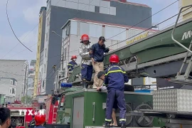 Khẩn trương giải cứu người khỏi đám cháy. (Ảnh: TTXVN phát)